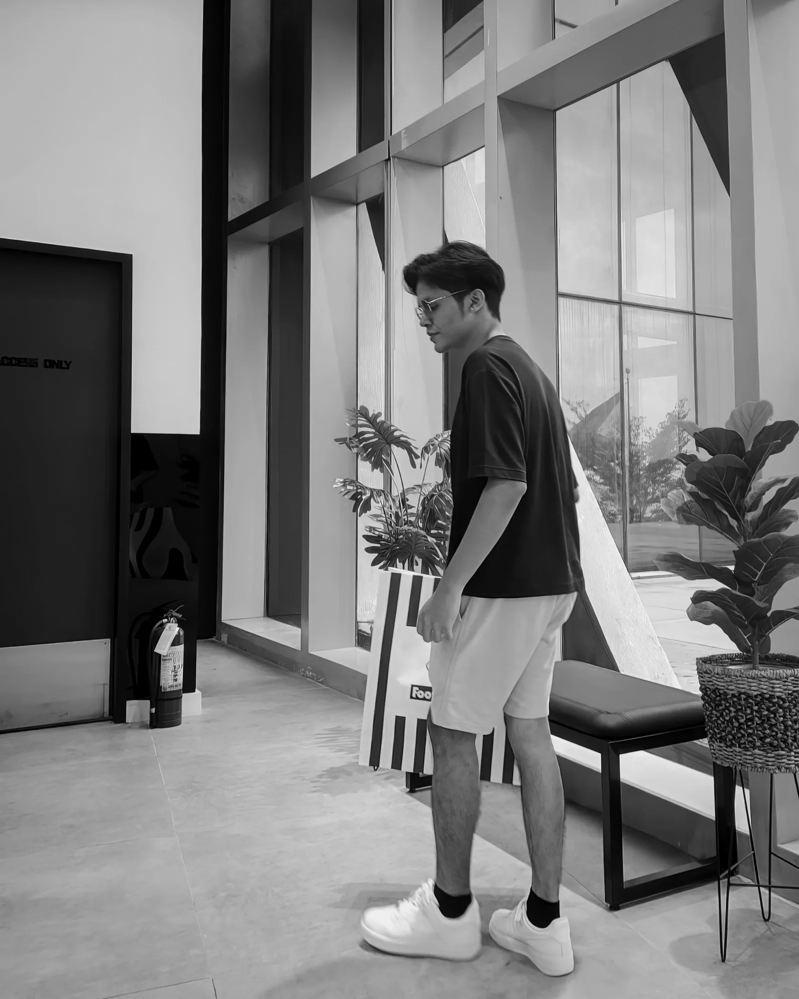 Earl Yamson standing in a bright lobby, in a dark shirt and light shorts